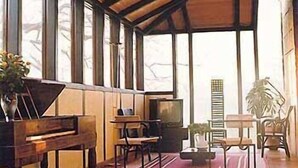 A spacious room with a wooden ceiling, large windows, a piano, and several chairs. - Pazo da Merced (Neda)