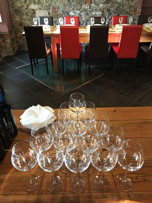 Un comedor con una mesa de madera dispuesta para una comida, rodeada de sillas rojas.