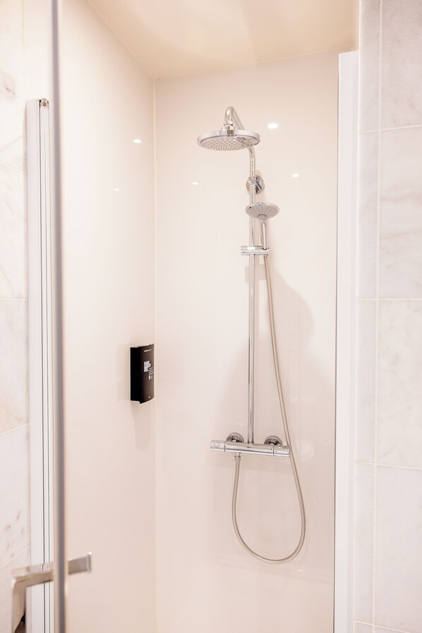 A modern shower with a handheld showerhead and a wall-mounted control panel. - Hotel Royal Astrid Aalst (Aalst)