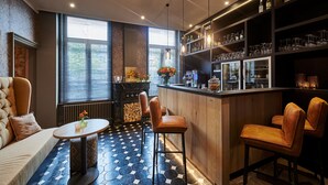 A bar area with a wooden counter, leather chairs, and a tiled floor. - Hotel Royal Astrid Aalst (Aalst)