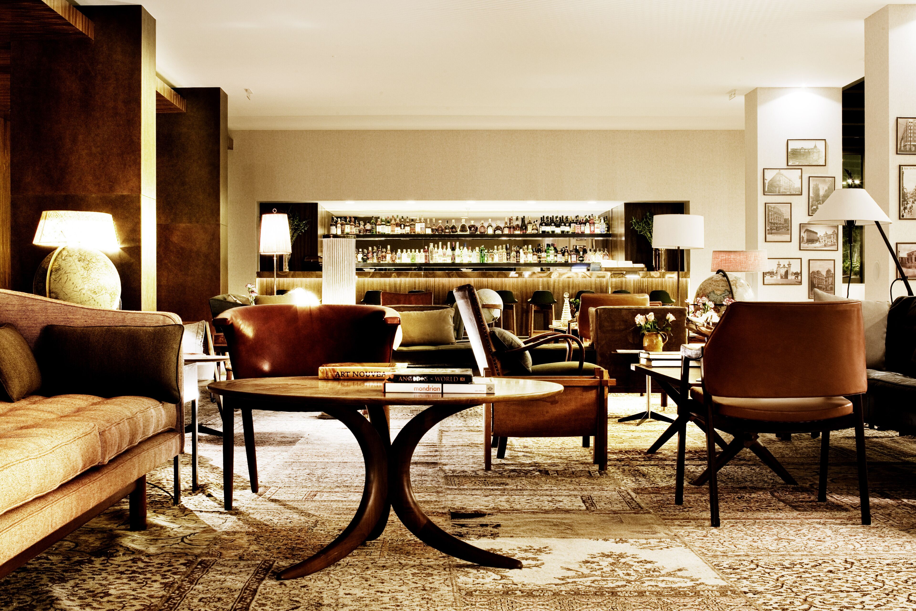 A hotel lobby with a bar area, seating arrangements, and a carpeted floor.