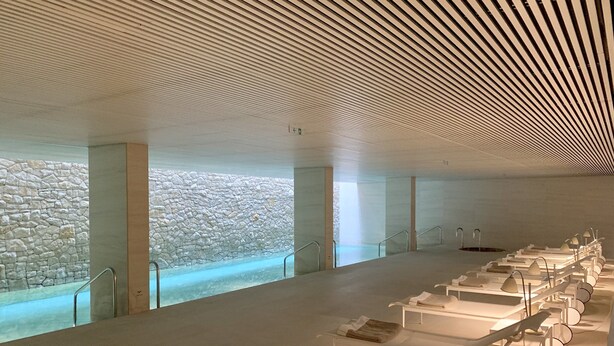 A modern spa with a stone wall, a pool, and multiple sun loungers. - Square Nine Hotel Belgrade-The Leading Hotels of The World (Belgrade)
