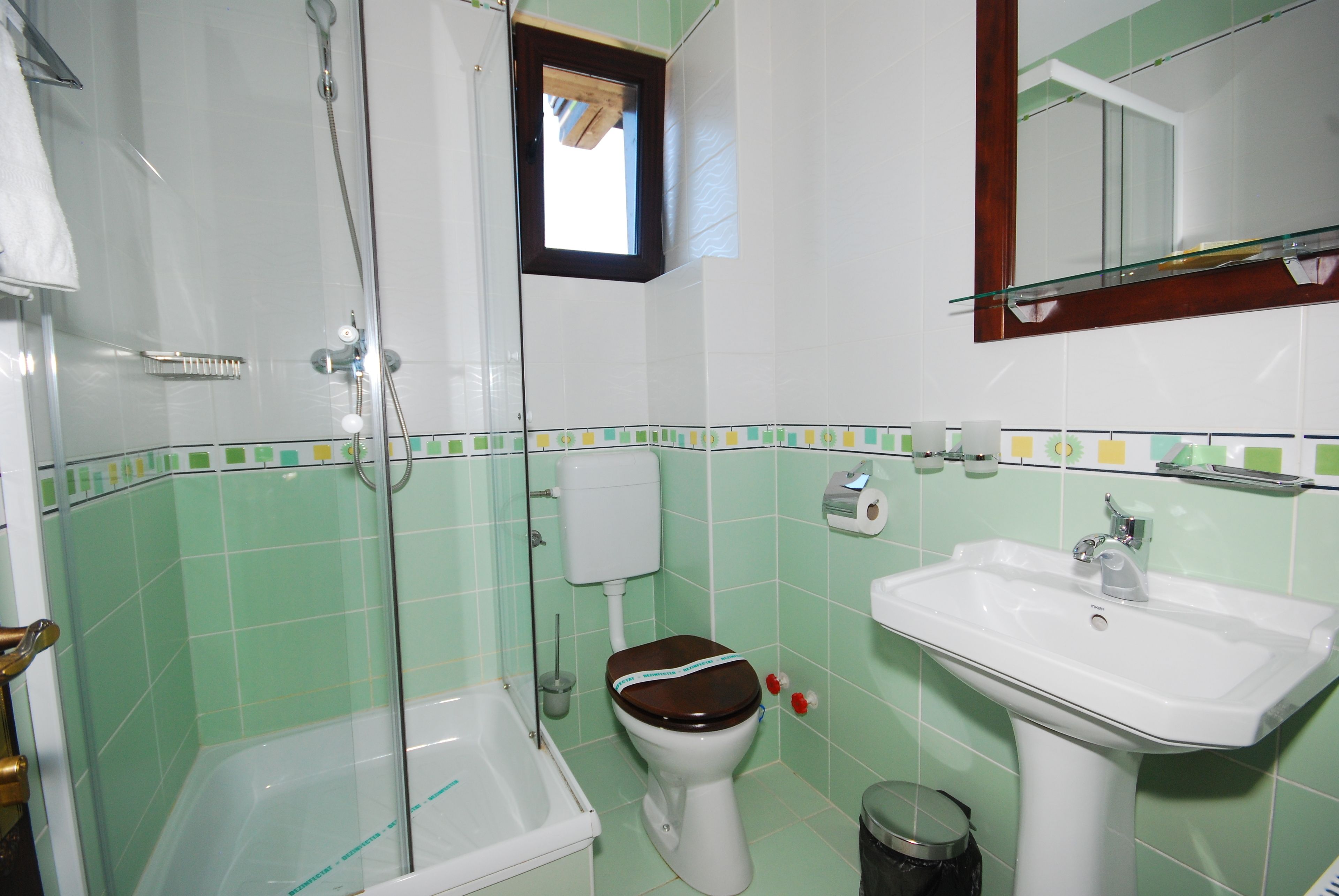 A bathroom with a shower, toilet, and sink.
