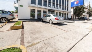 A hotel with a modern facade, large windows, and a sign indicating it is a hotel suites. - Suites Internacional (Zapopan)