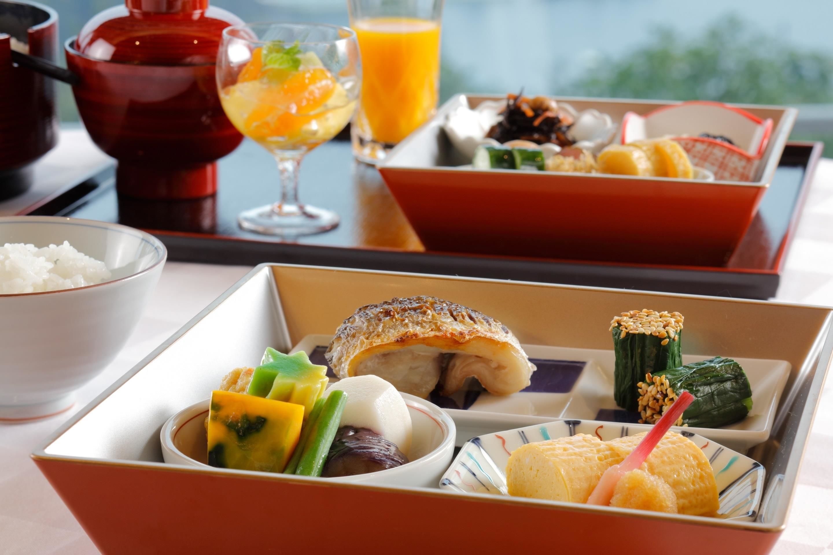 A meal tray with various dishes including rice, vegetables, and a fish dish.