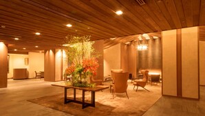 A spacious lobby with a wooden ceiling, a central table with a floral arrangement, and several seating areas. - Shima Kanko Hotel The Classic (Shima)