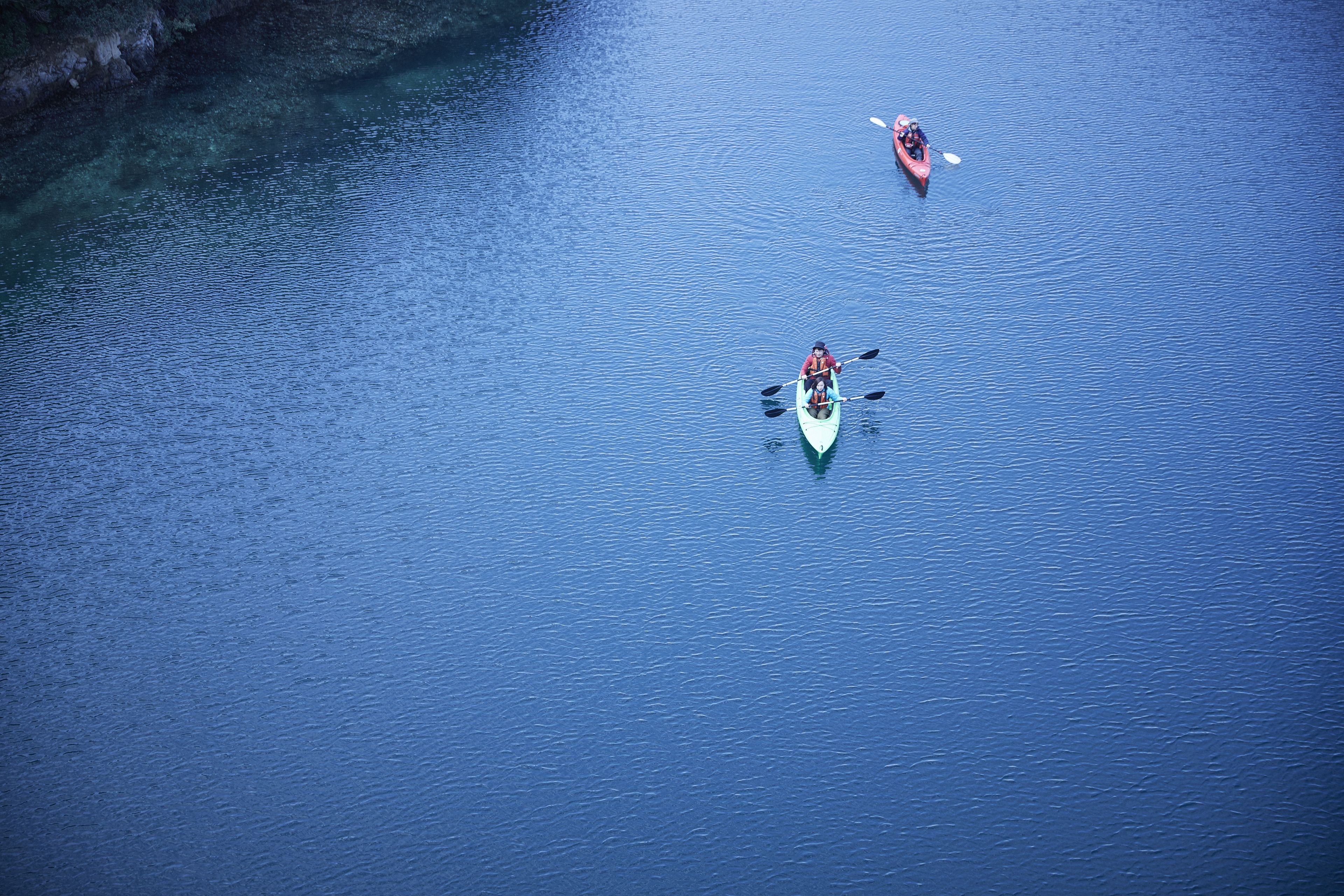 A calm body of water with kayaks.