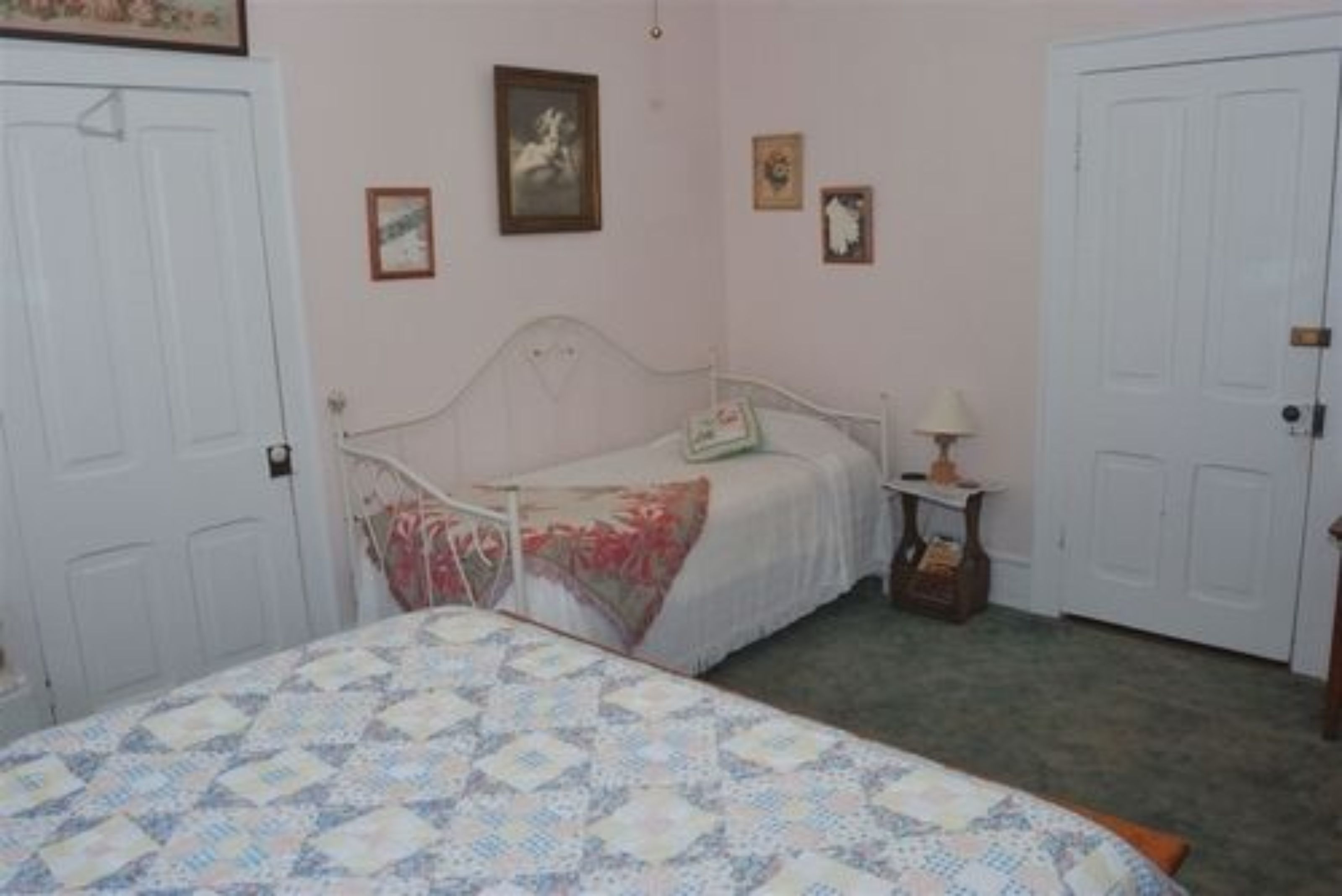 A bedroom with a bed, a nightstand, and a dresser.