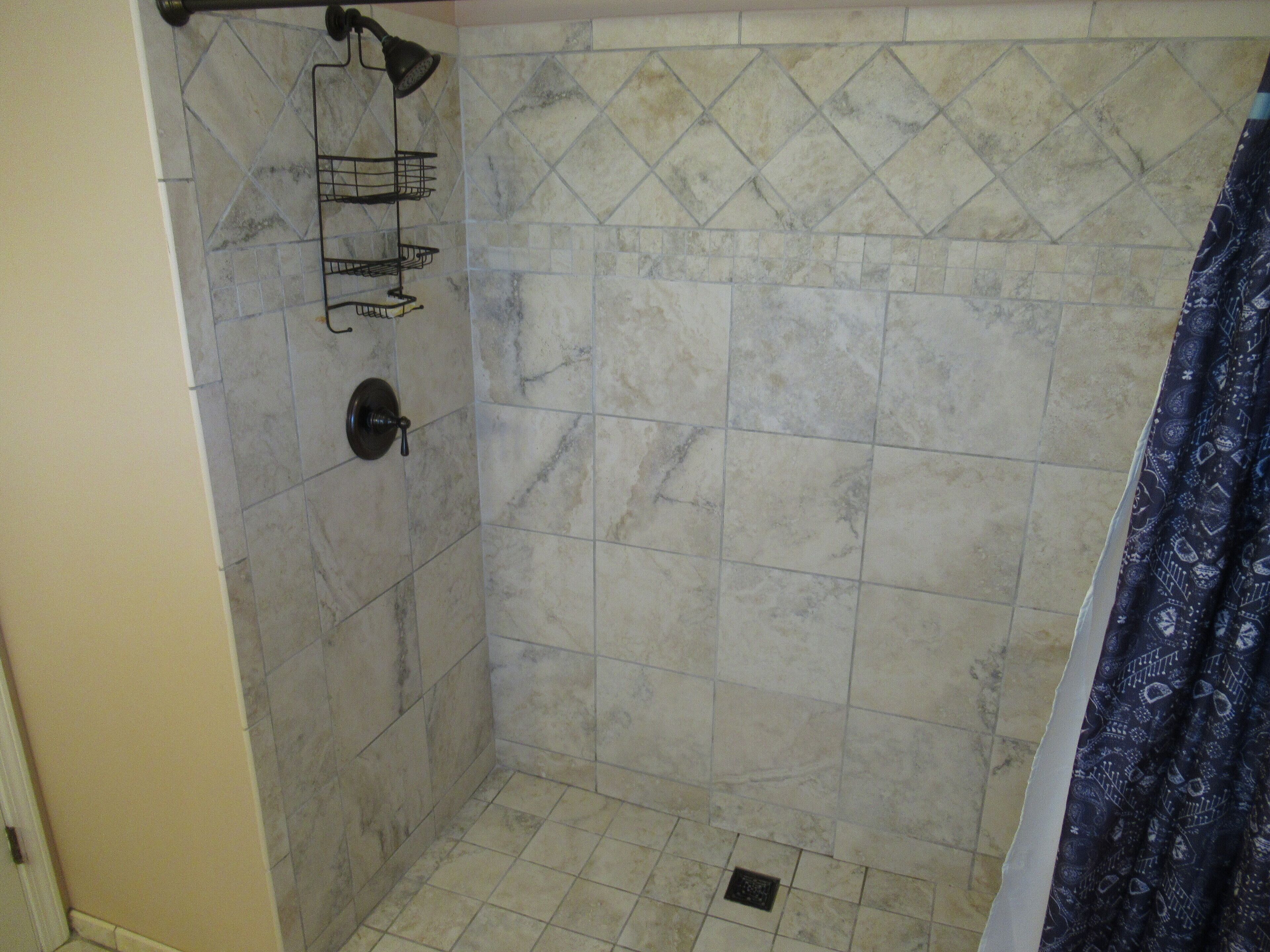 A bathroom with a shower area, tiled walls, and a shower curtain.