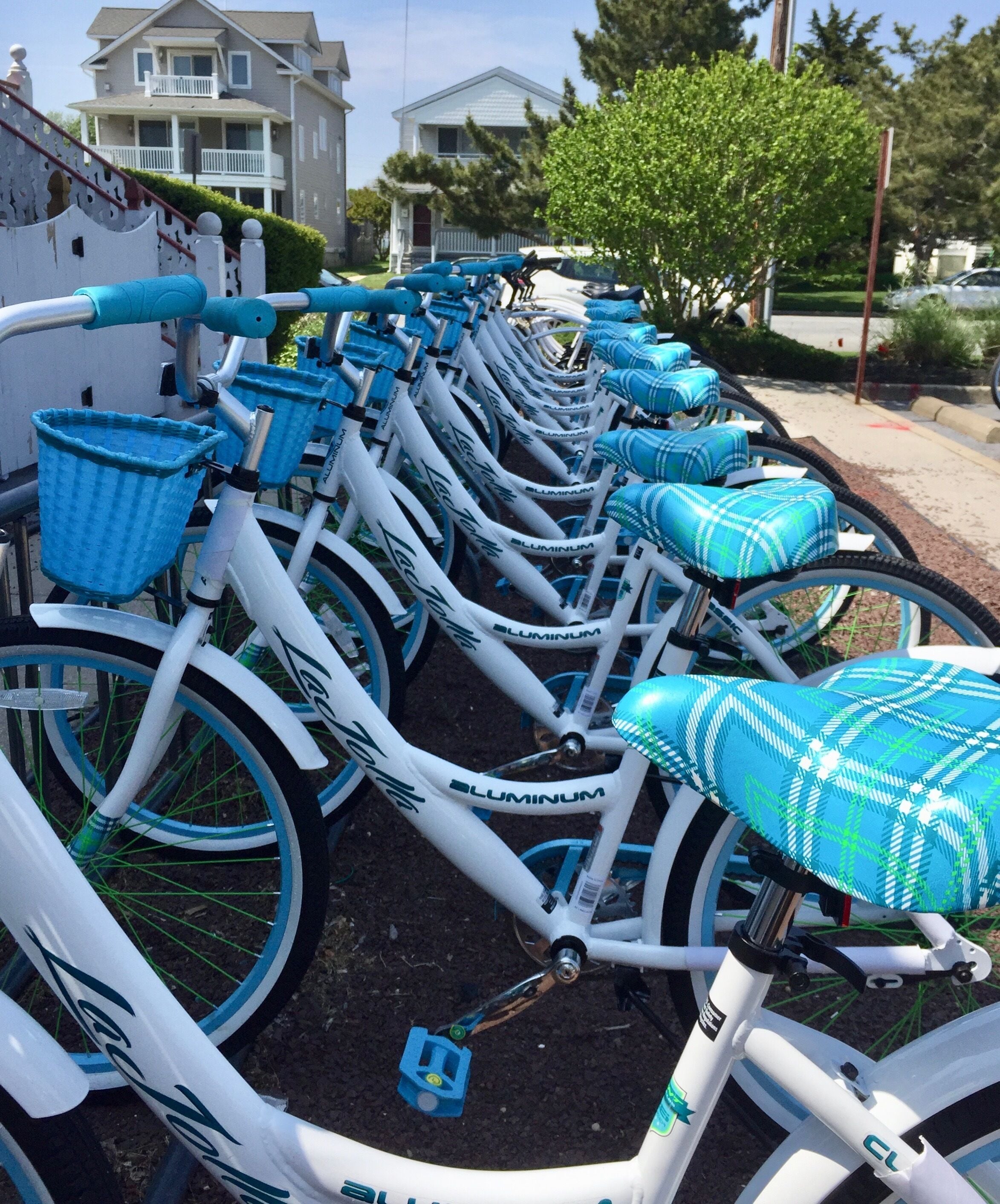 A row of bicycles parked in a row, each with a blue basket and seat.