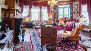 A traditional room with wooden furniture, a chandelier, and a red carpet.