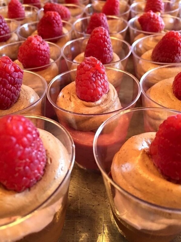 A row of dessert cups with a raspberry on top. - Angel of the Sea (Cape May)