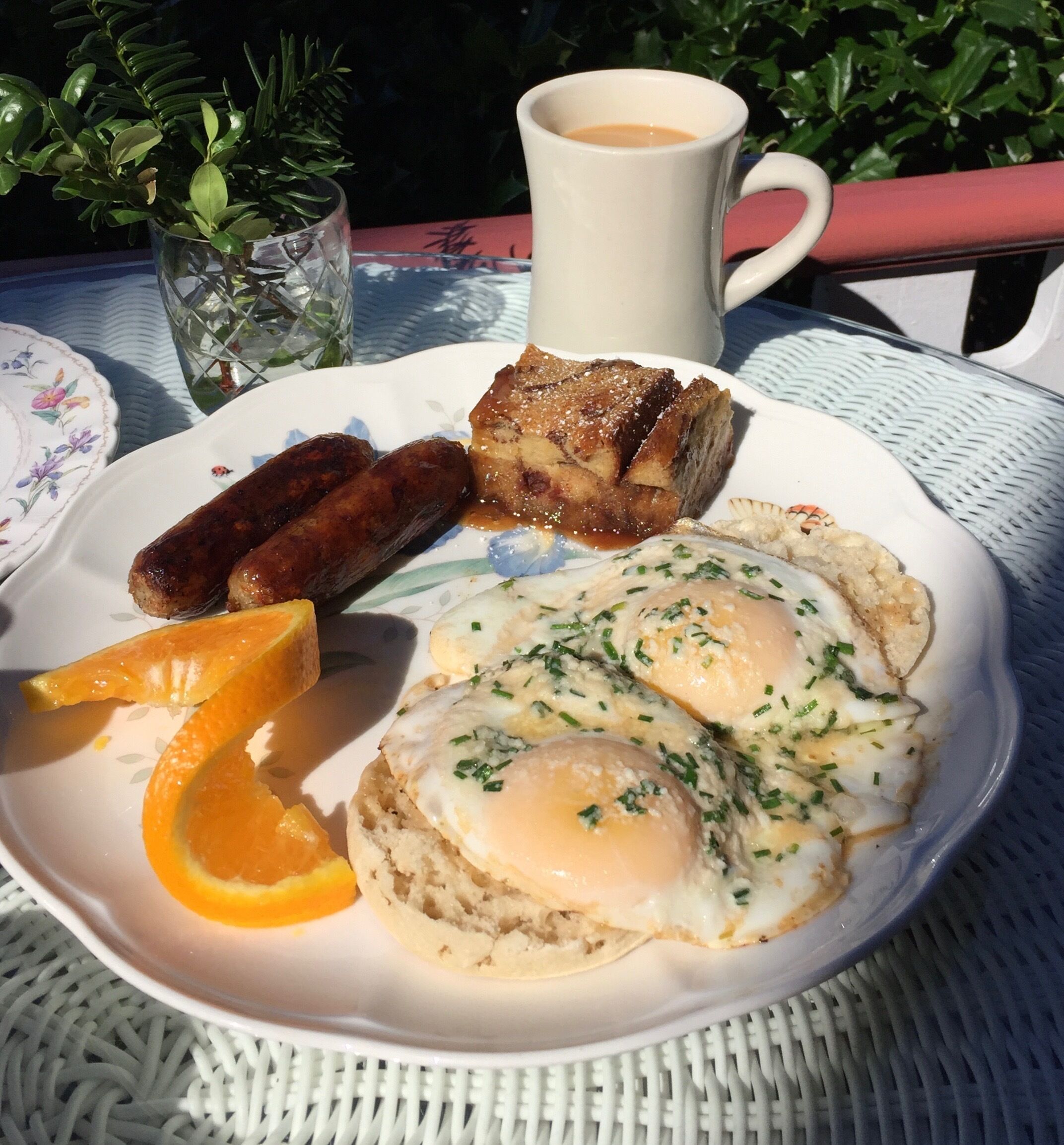 Une assiette avec des œufs, des saucisses, des toasts et une tranche d’orange.