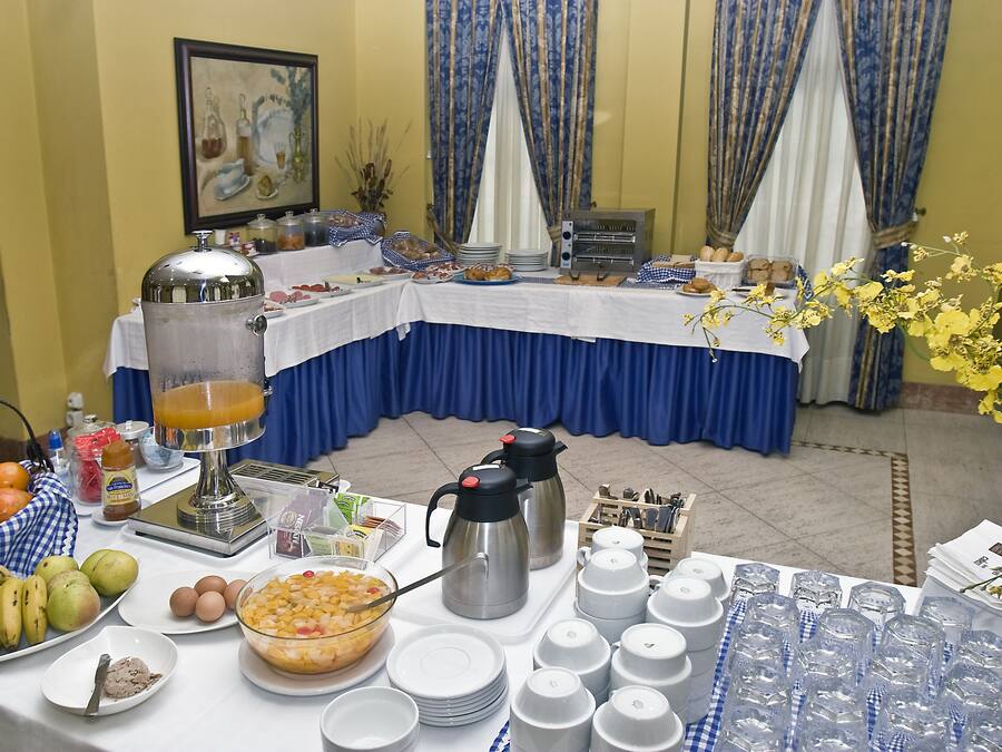 Montaje de bufé con diversos alimentos, un dispensador de bebidas y una cafetera.