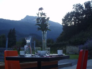A table set outdoors with a vase of flowers, a glass pitcher, and cups. - Ellauri Hotel, Landscape SPA - Adults Only (Zeanuri)