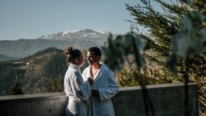 Two people in white bathrobes standing on a wooden platform with a mountainous landscape in the background. - Ellauri Hotel, Landscape SPA - Adults Only (Zeanuri)
