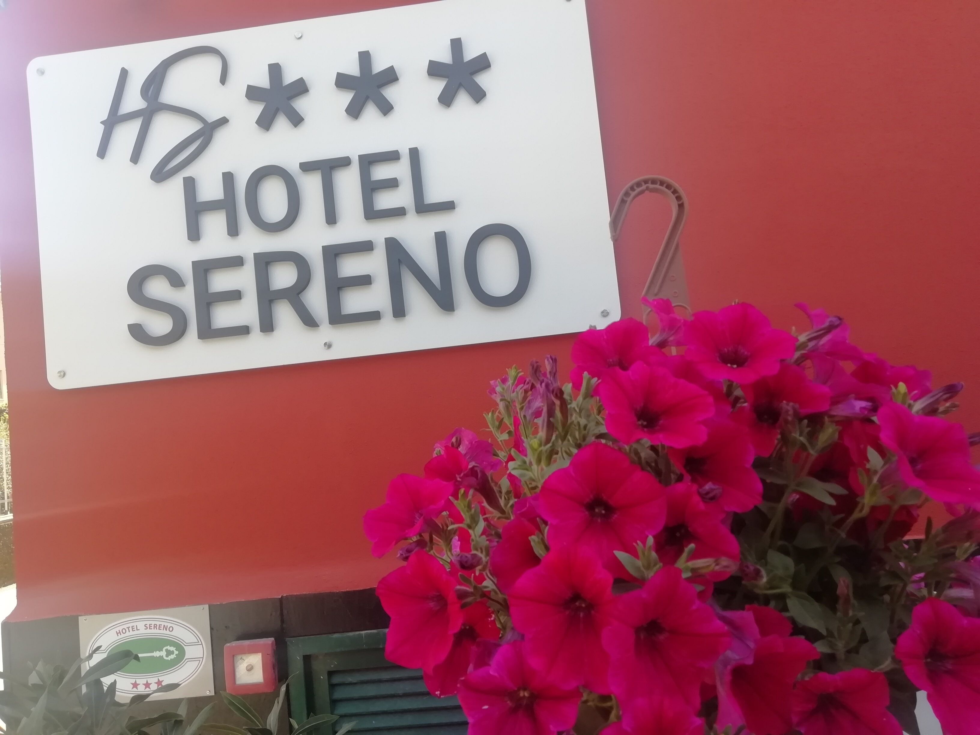 Señal para el Hotel Sereno con un borde decorativo y un logo debajo.