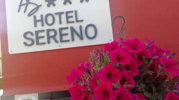 Señal para el Hotel Sereno con un borde decorativo y un logo debajo.