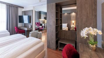 Une chambre d’hôtel dotée d’un grand lit, d’un bureau, d’une télévision, d’un coin salon et d’une armoire.