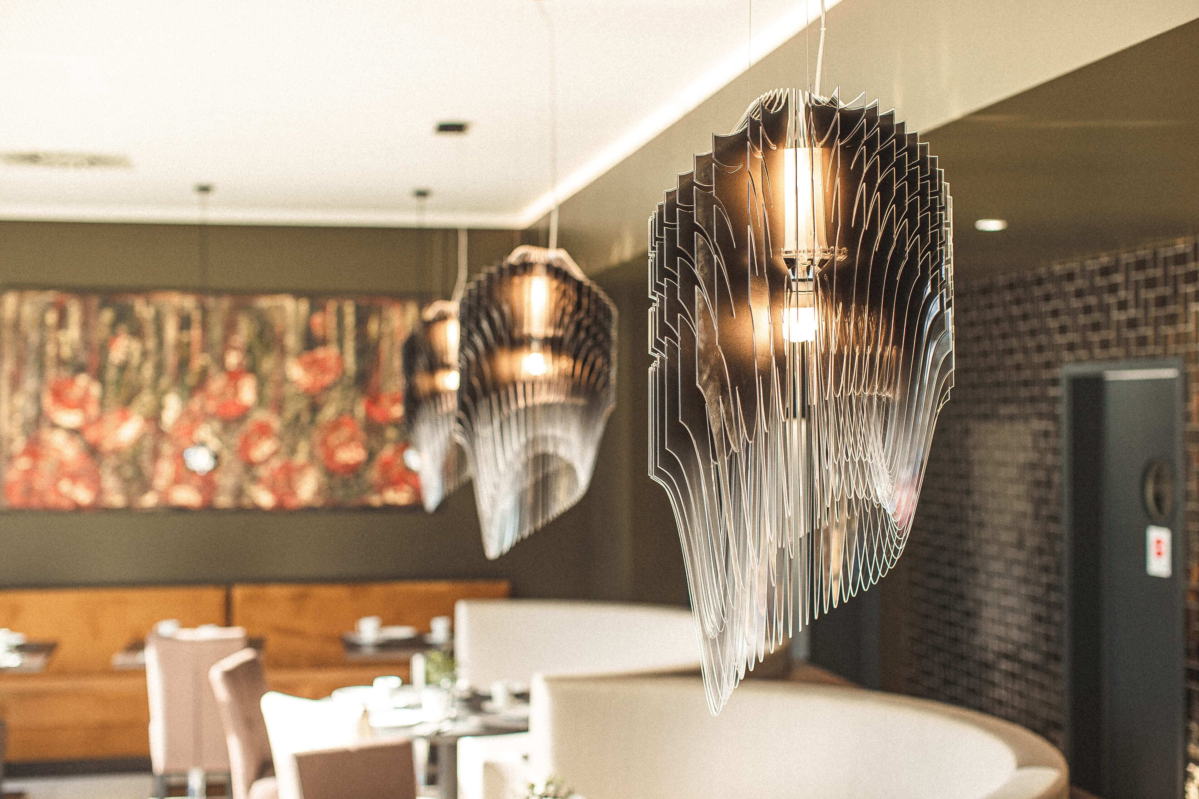 Un interno moderno con lampade a sospensione, una zona salotto e un pannello decorativo.