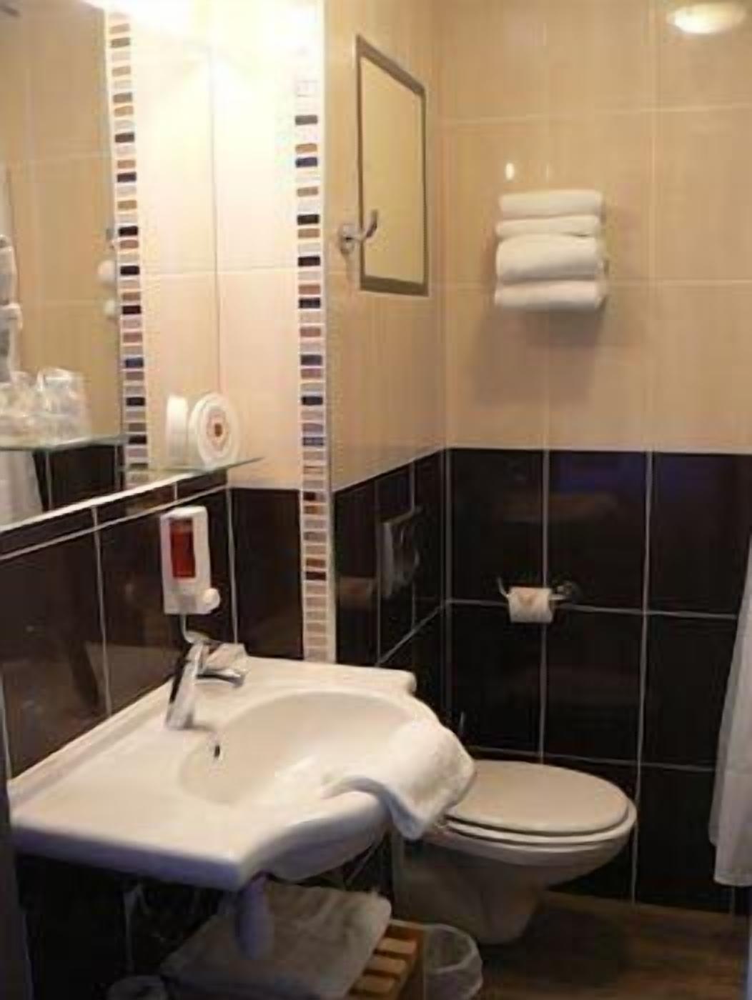 Ein Badezimmer mit Waschbecken, Toilette und Handtuchhalter.