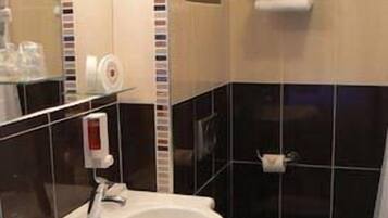 Ein Badezimmer mit Waschbecken, Toilette und Handtuchhalter.