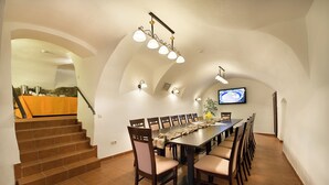 Comedor con una mesa larga, sillas y una escalera que sube a un nivel superior.