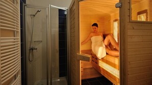 Un sauna con un banco de madera y un ventanal que da a una zona de ducha.