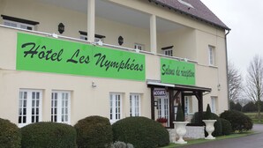Un edificio con un cartel que dice "Hotel Les Nymphéas" y "Salones de recepción".