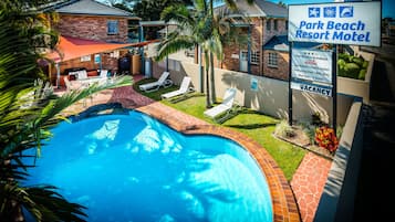 Una piscina al aire libre, sillones reclinables de piscina