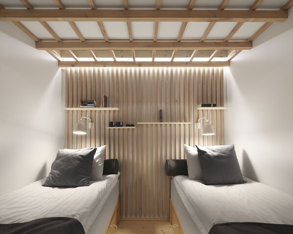 Un dormitorio con dos camas individuales, paredes de listones de madera y estanterías empotradas con libros y objetos decorativos.