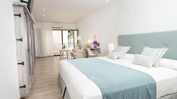 Junior suite, uitzicht op zee | Een minibar, een kluis op de kamer, individueel gedecoreerd, een bureau