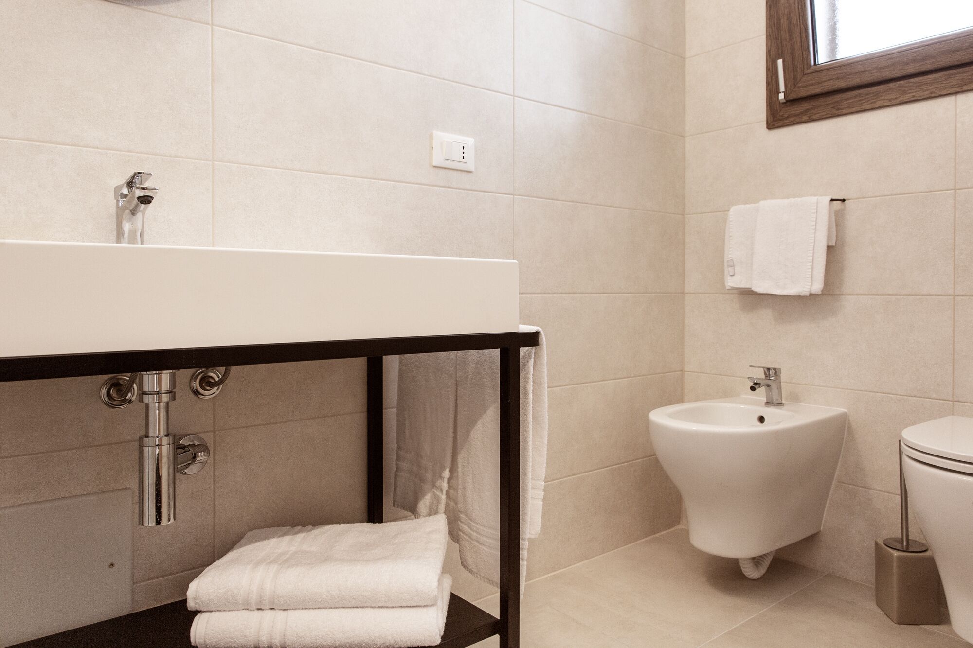 Une salle de bain moderne avec un lavabo blanc, un bidet et des toilettes.