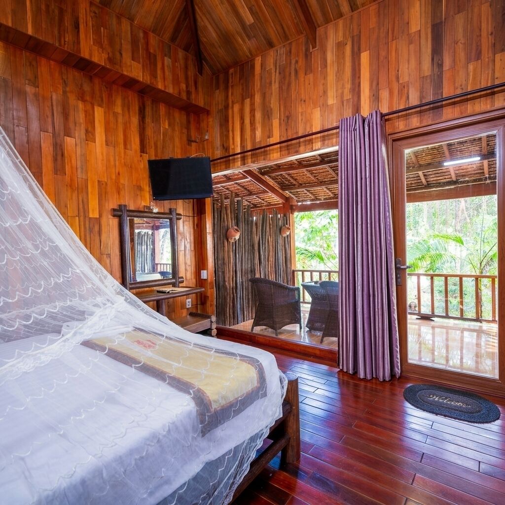 Quarto de madeira com uma cama, televisão e vista para o exterior.