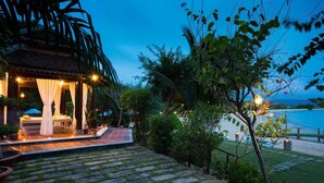 A well-lit outdoor seating area with a view of the sea, surrounded by lush greenery and a stone pathway. - Milana Beach Resort & Spa Phu Quoc (Phu Quoc)