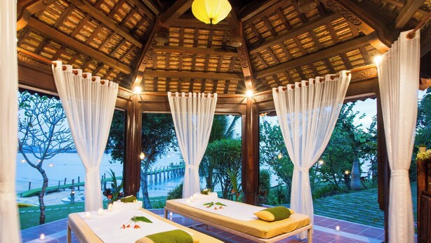 A spa area with two massage tables, white curtains, and a wooden ceiling. - Milana Beach Resort & Spa Phu Quoc (Phu Quoc)
