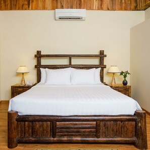 A bed with a wooden headboard, white bedding, and two bedside tables with lamps and a vase. - Milana Beach Resort & Spa Phu Quoc (Phu Quoc)