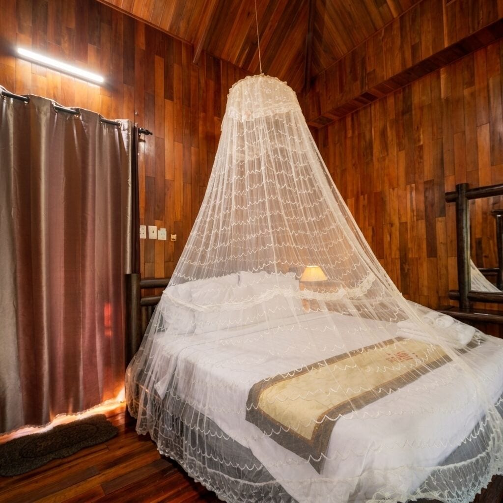 Una habitación con cama cubierta por un dosel blanco.