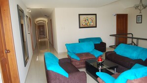 A living room with a sofa set, a coffee table, and a painting on the wall.