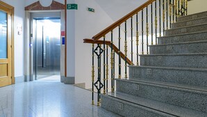 A polished granite staircase with a wooden handrail and ornate black and gold balusters. - Alda Ciudad de Toro (Toro)