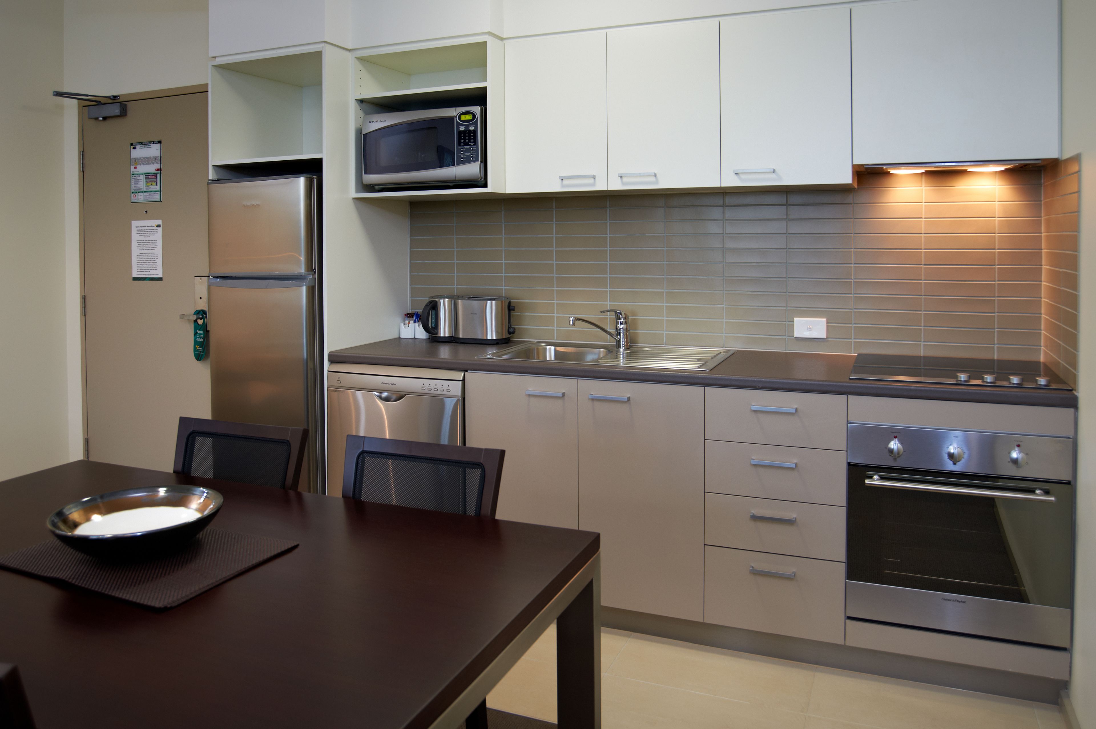 Een moderne keuken met roestvrijstalen apparatuur, een vaatwasser en een magnetron.