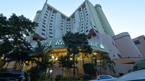 Un hotel de diseño moderno, con una entrada curva destacada y varios pisos.