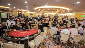 Un gran evento en interiores con escenario, público sentado y alfombra roja.