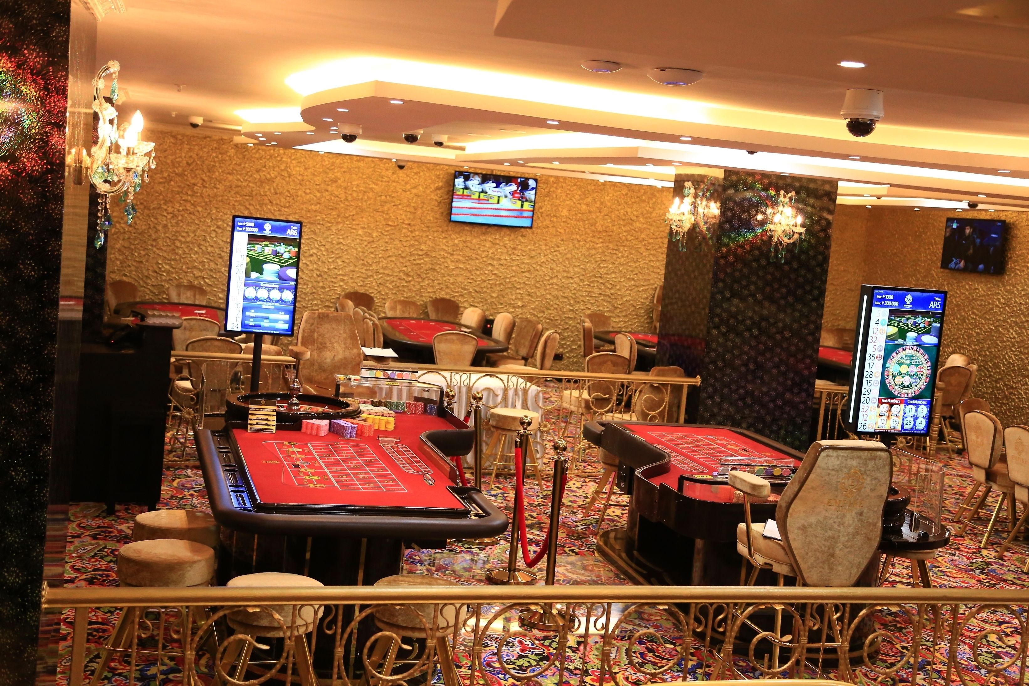 A casino with multiple blackjack tables, chairs, and slot machines.