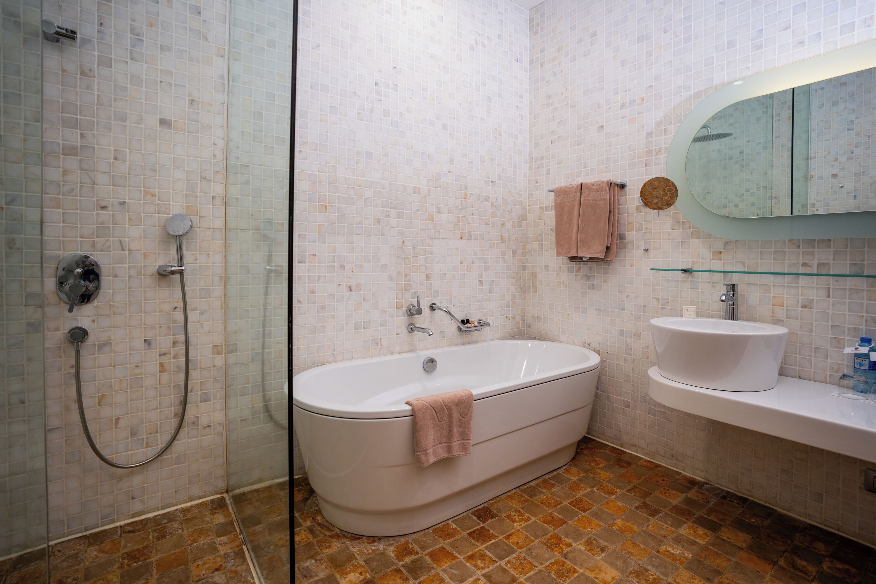 Ein Badezimmer mit einer Duschkabine, einer weißen Badewanne und einem Waschbecken mit Spiegel darüber.
