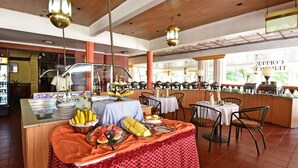 A buffet setup with various food items and a seating area with tables and chairs. - Grand Imperial Hotel (Kampala)