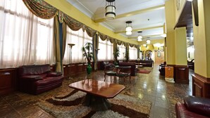 A spacious lobby with leather sofas, a wooden coffee table, and a large rug. - Grand Imperial Hotel (Kampala)