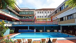 A hotel with a swimming pool, multiple balconies, and outdoor seating areas. - Grand Imperial Hotel (Kampala)