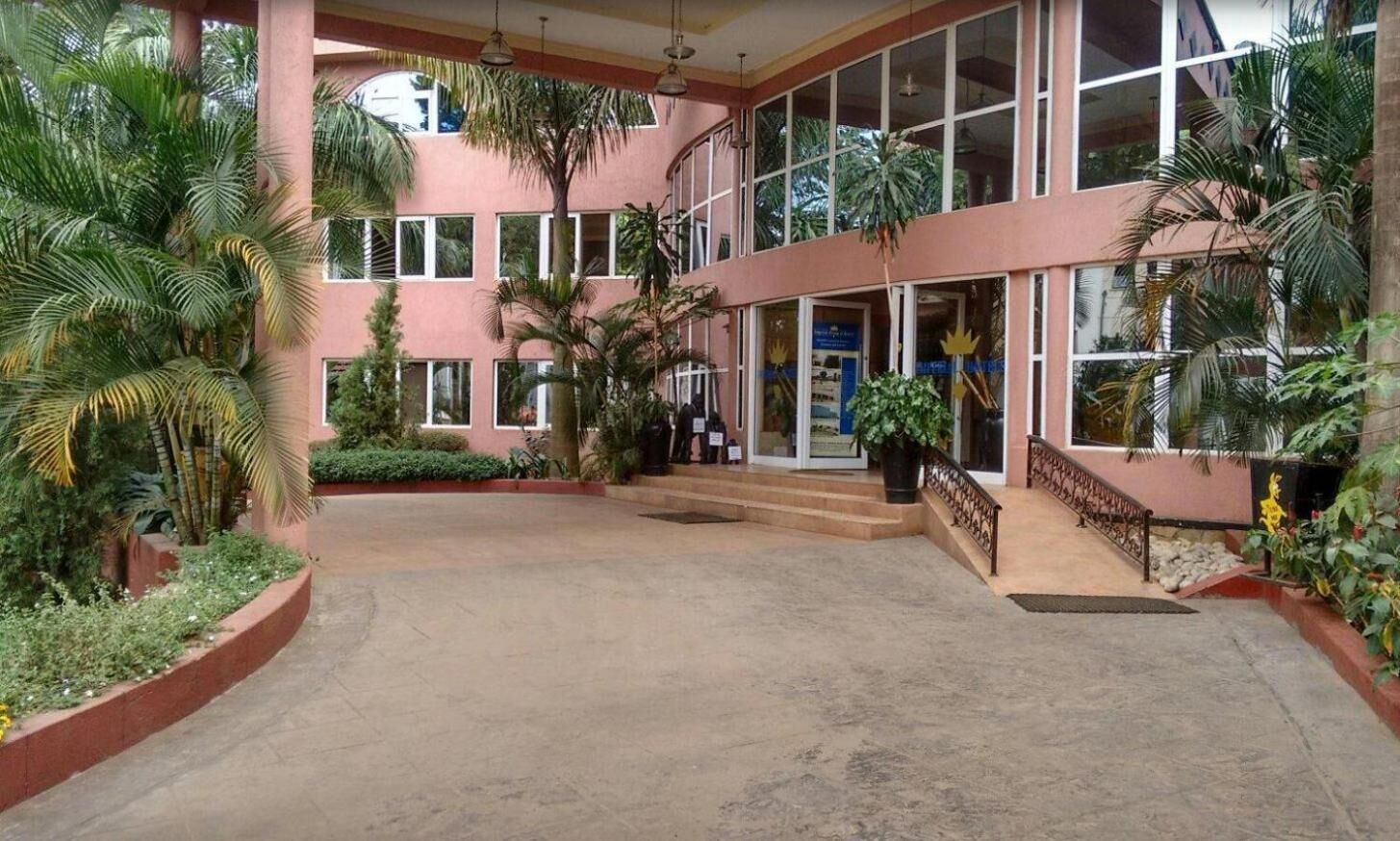A building with a pink facade, large windows, and a central entrance with steps.
