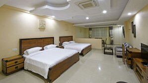 A hotel room with two wooden beds, a TV, a desk, and a chair. - Imperial Golf View Hotel (Entebbe)